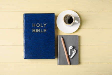 Holy Bible, cup of coffee and earphones on wooden backgroundの写真素材