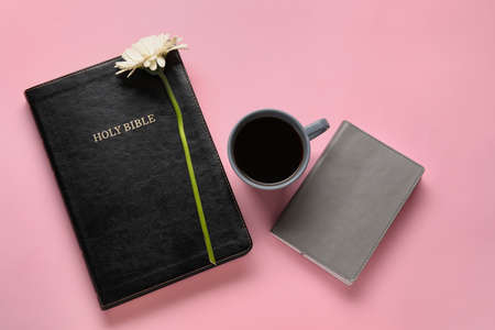 Holy Bible, cup of coffee and flower on color backgroundの写真素材