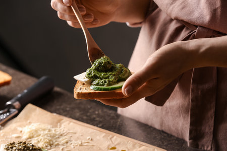 Woman making tasty toast with pesto sauce, closeupの写真素材