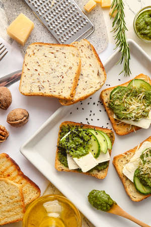 Tasty toasts with pesto sauce on light backgroundの写真素材