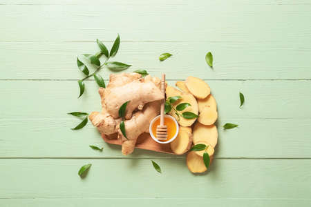 Composition with fresh ginger on color wooden background