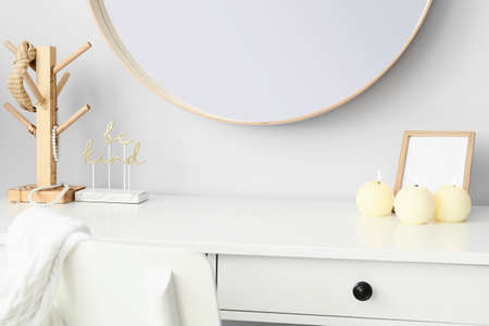 Decor and candles on table near light wallの写真素材