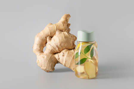 Fresh ginger and bottle of lemonade on gray backgroundの写真素材