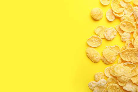 Tasty corn flakes on color background