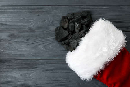 Christmas sock with coal on dark wooden backgroundの写真素材