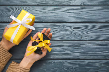 Woman with coal and Christmas gift on dark wooden backgroundの写真素材
