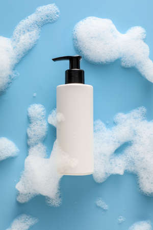 Bottle of cosmetic product with foam on color backgroundの写真素材
