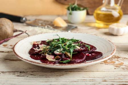 Plate with delicious beetroot carpaccio on white wooden tableの写真素材