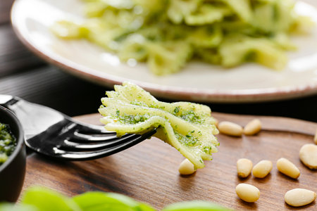 Eating tasty pesto pasta, closeup