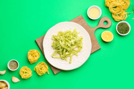 Plate with tasty pesto pasta on color background