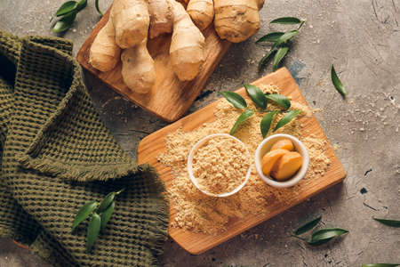 fresh and ground ginger on grunge background