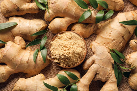 Fresh and ground ginger on table