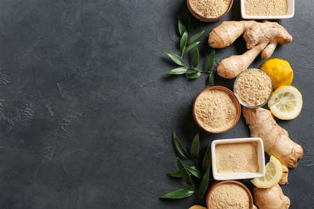 Bowls with ginger powder on dark background