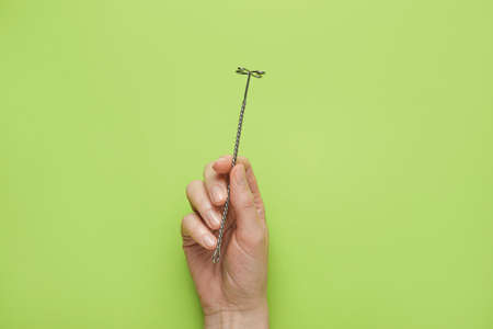 Female hand and logopedic tool for speech correction on color backgroundの写真素材