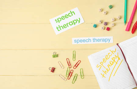 Composition with text SPEECH THERAPY and notebook on color wooden backgroundの写真素材