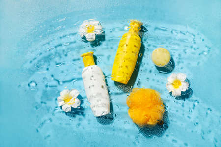Bath supplies and flowers in water on color backgroundの写真素材