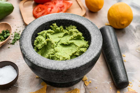 Mortar with tasty guacamole on color background, closeupの写真素材