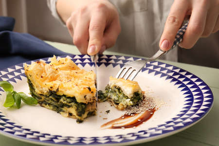 Woman eating tasty green lasagna, closeupの写真素材