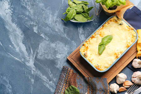 Composition with tasty green lasagna and ingredients on color background