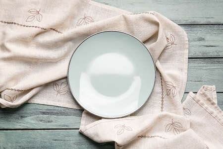 Fabric napkin and plate on color wooden backgroundの写真素材