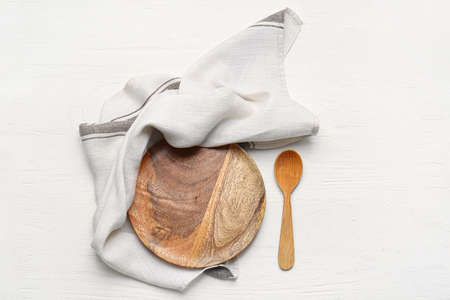 Fabric napkin, plate and spoon on light wooden backgroundの写真素材