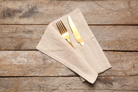 Holder with cutlery on wooden background