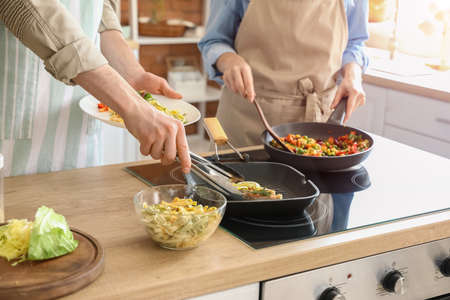 young couple cooking in the kitchenの写真素材