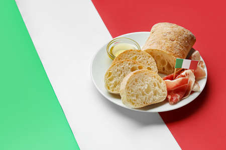 Plate with traditional Italian food on color background