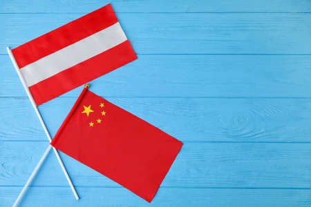 Flags of Latvia and China on color wooden background