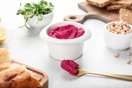 Composition with tasty beet hummus and ingredients on light backgroundの写真素材