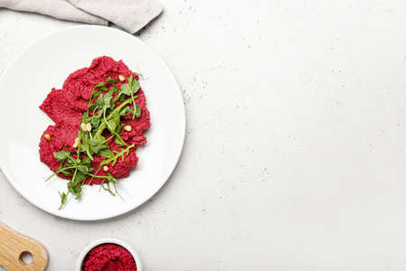 Plate with tasty beet hummus and fresh sprouts on light backgroundの写真素材