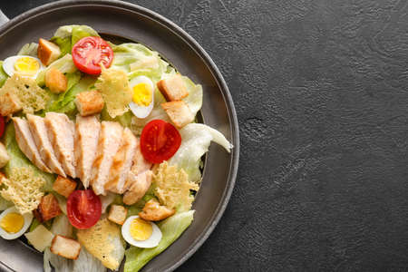 Plate with tasty Caesar salad on dark backgroundの写真素材