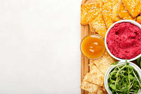 Board with tasty beet hummus and snacks on light background, closeupの写真素材