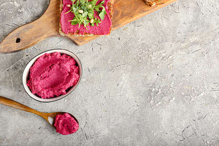 Bowl and spoon with tasty beet hummus on grunge backgroundの写真素材