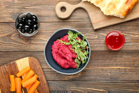 Composition with tasty beet hummus, olives, carrots and sauce on wooden backgroundの写真素材