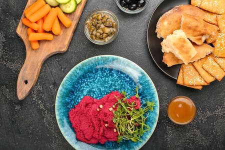 Composition with tasty beet hummus and snacks on dark backgroundの写真素材
