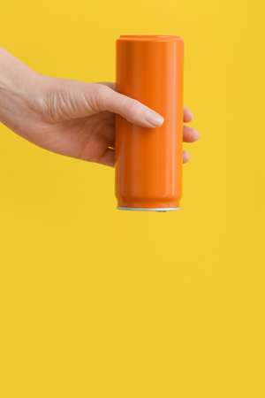 Hand with can of soda on color backgroundの写真素材