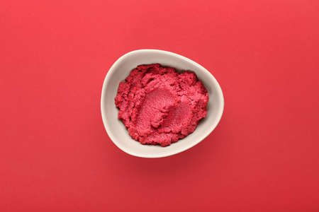 Bowl with tasty beet hummus on color backgroundの写真素材