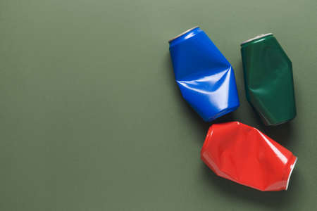 Crumpled cans of soda on color backgroundの写真素材