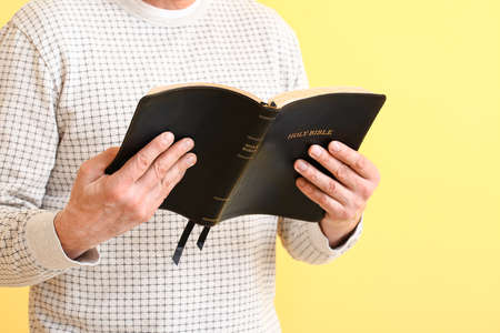 Man with Bible on color background, closeupの写真素材