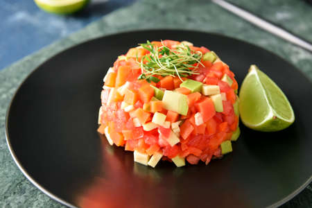 Plate with tasty tartare salad and lime, closeupの写真素材