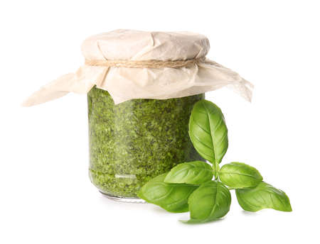 Jar with fresh pesto sauce and basil leaves on white backgroundの写真素材