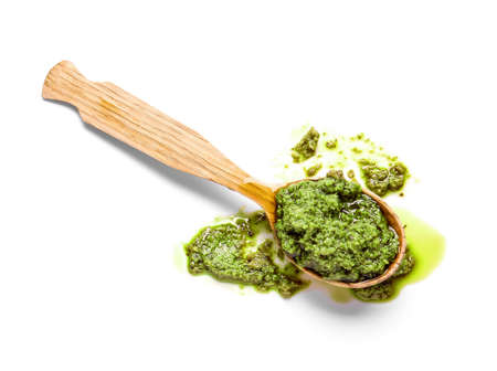Spoon with fresh pesto sauce on white backgroundの写真素材