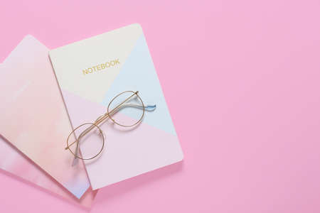 Stylish eyeglasses with notebooks on color backgroundの写真素材