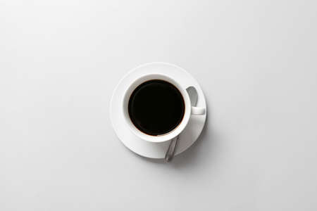 Cup of aromatic coffee on light background