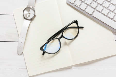 Composition with eyeglasses and notebook on white wooden backgroundの写真素材