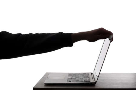 Silhouette of hacker's hand and laptop on white backgroundの写真素材