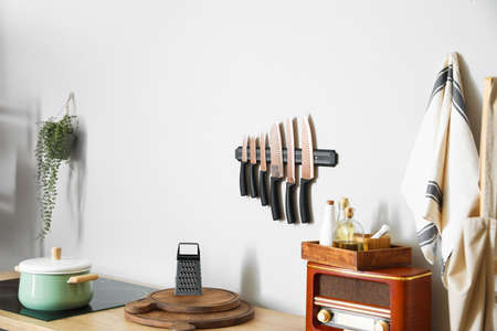 Kitchen utensils with food and retro radio receiver on counter near light wallの写真素材