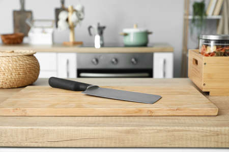 Board with knife on table in kitchenの写真素材