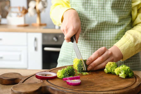 Woman cutting broccoli in kitchen, closeupの写真素材